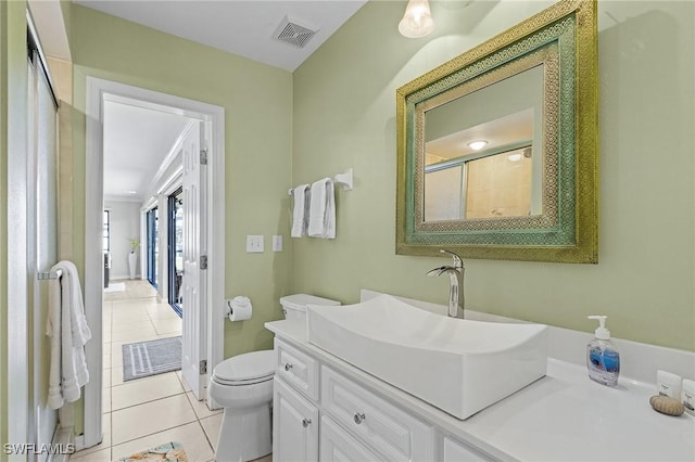 bathroom with tile patterned floors, vanity, toilet, and an enclosed shower