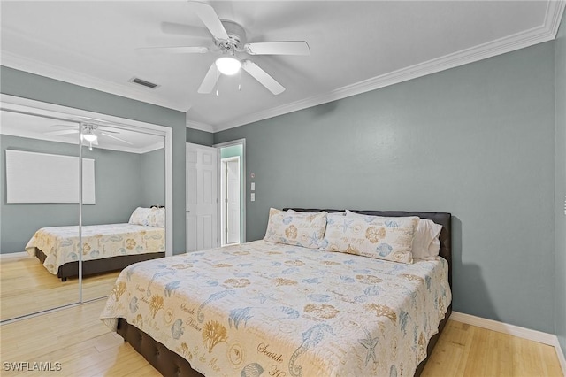 bedroom with a closet, light hardwood / wood-style flooring, ceiling fan, and crown molding