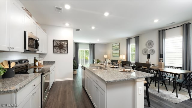 kitchen featuring white cabinetry, a kitchen island with sink, sink, and appliances with stainless steel finishes