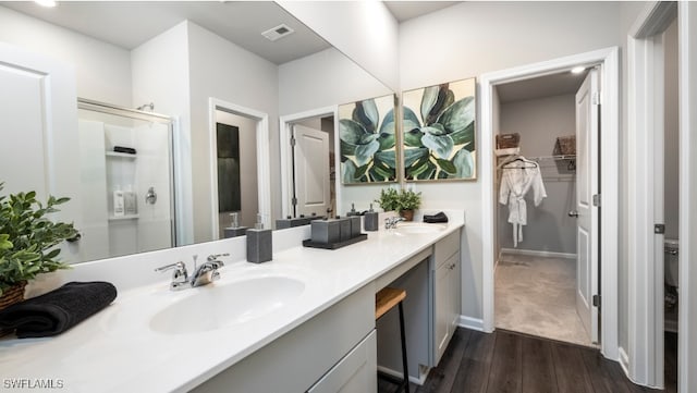 bathroom featuring hardwood / wood-style floors, vanity, and a shower with shower door