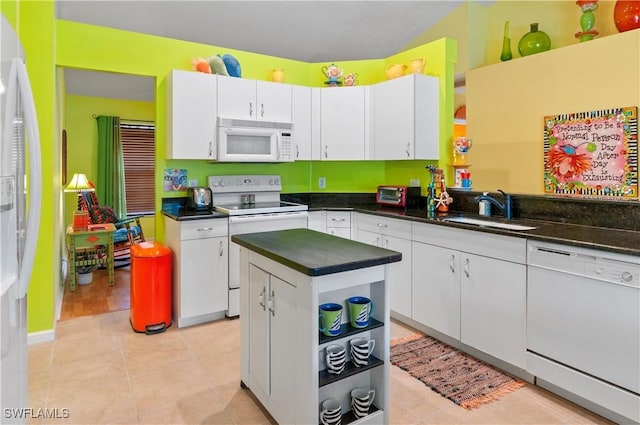 kitchen featuring white cabinetry, sink, a center island, and white appliances