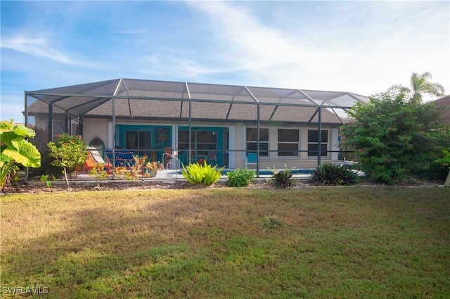 back of property with a lawn and glass enclosure