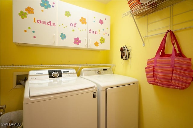 clothes washing area with cabinets and washer and dryer