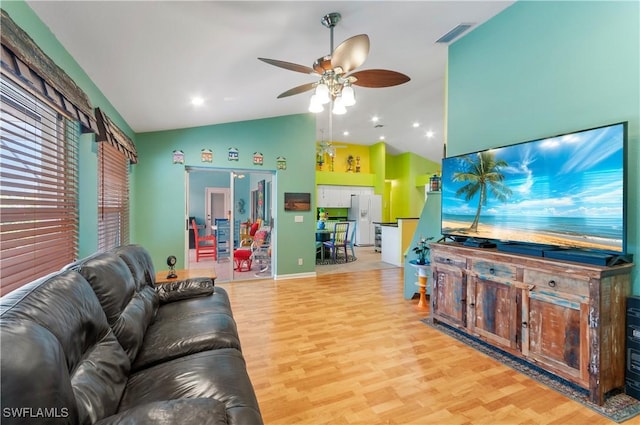 living room with ceiling fan, lofted ceiling, and light wood-type flooring