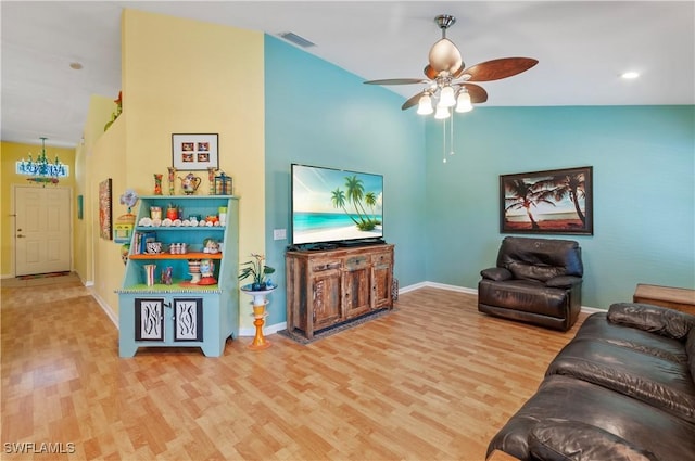 living room with hardwood / wood-style floors, ceiling fan, and lofted ceiling