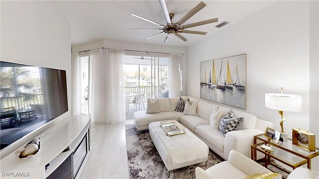 living room featuring ceiling fan and light hardwood / wood-style floors