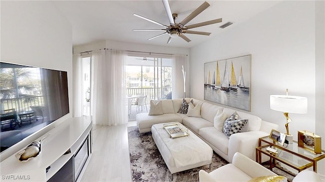 living room with visible vents, ceiling fan, and wood finished floors