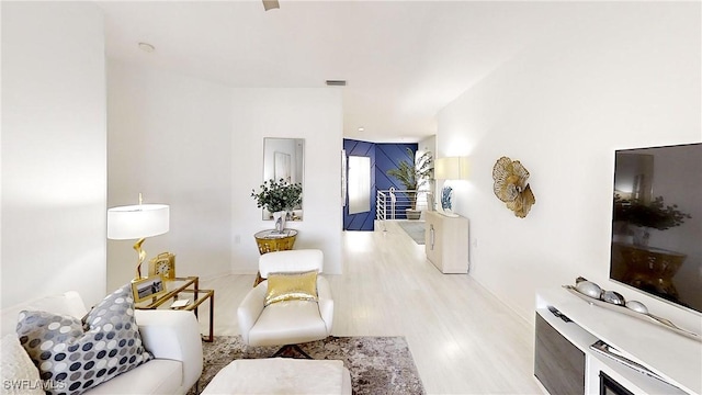 living area with wood finished floors and visible vents