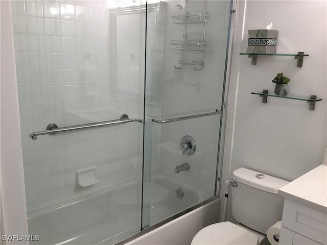 full bathroom featuring toilet, combined bath / shower with glass door, and vanity