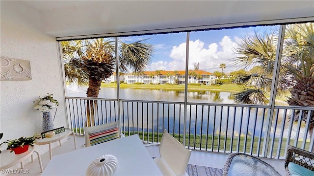 sunroom / solarium featuring a water view