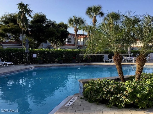 pool with a patio area and fence