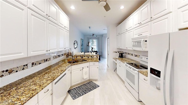 kitchen with white appliances, a sink, a ceiling fan, and white cabinets