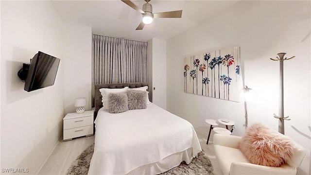 bedroom featuring ceiling fan, baseboards, and wood finished floors