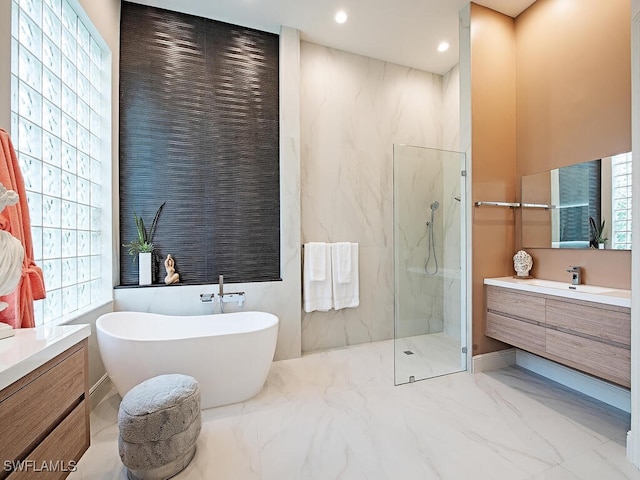 bathroom with shower with separate bathtub, plenty of natural light, and vanity