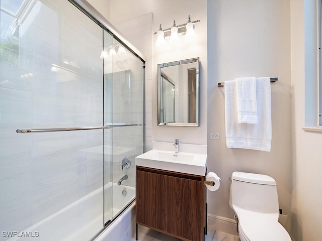 full bathroom featuring enclosed tub / shower combo, vanity, and toilet