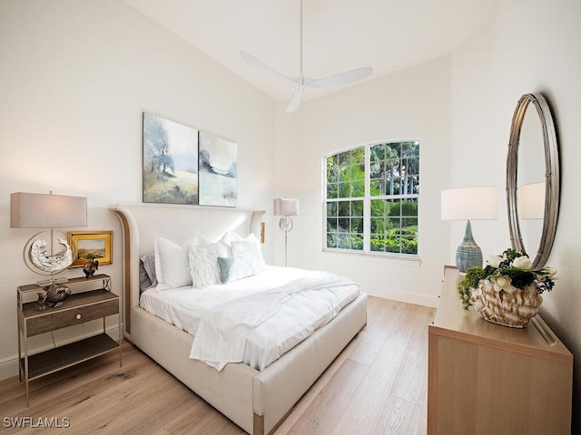 bedroom featuring ceiling fan, vaulted ceiling, and light wood-type flooring