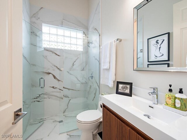 bathroom with vanity, a shower with shower door, and toilet