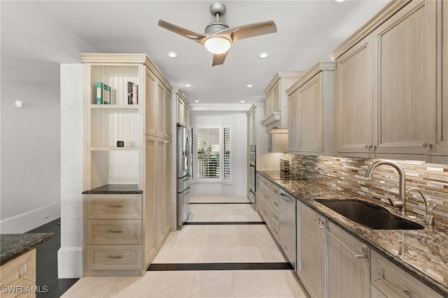 kitchen featuring light brown cabinets, dark stone counters, sink, tasteful backsplash, and stainless steel appliances