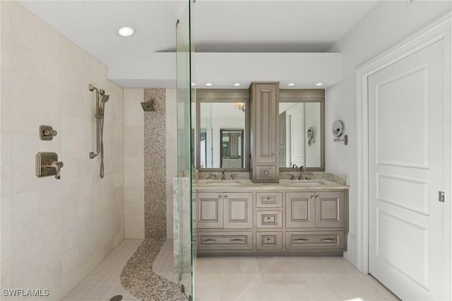 bathroom with a tile shower and vanity