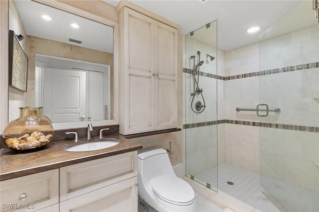 bathroom featuring vanity, an enclosed shower, and toilet