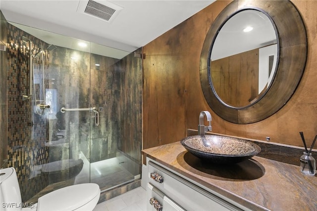 bathroom with tile patterned floors, vanity, toilet, and walk in shower