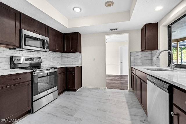 kitchen featuring dark brown cabinets, sink, and appliances with stainless steel finishes