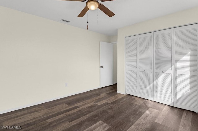 unfurnished bedroom with dark hardwood / wood-style floors, a closet, and ceiling fan