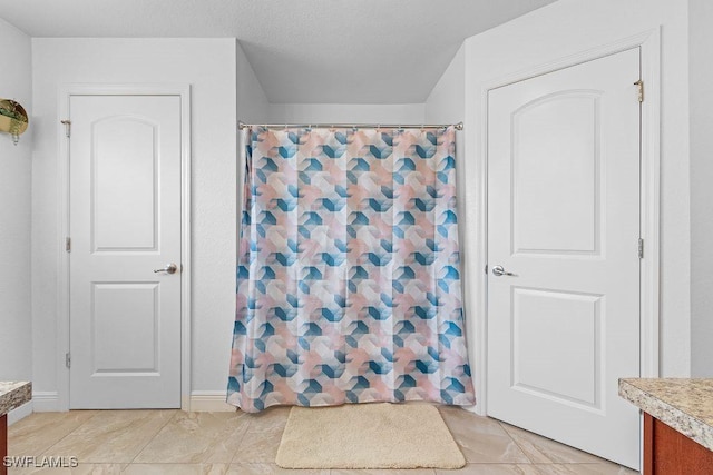 bathroom with tile patterned floors, vanity, and curtained shower