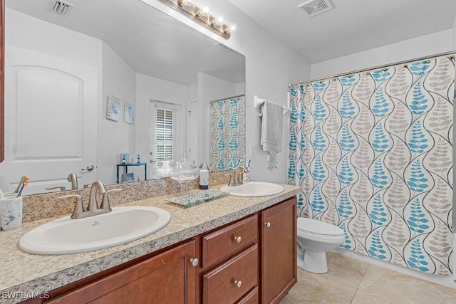 bathroom with tile patterned flooring, vanity, and toilet