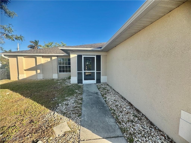 view of exterior entry with a yard