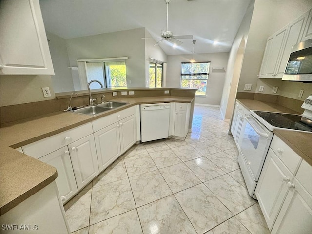 kitchen with vaulted ceiling, white cabinetry, and white appliances