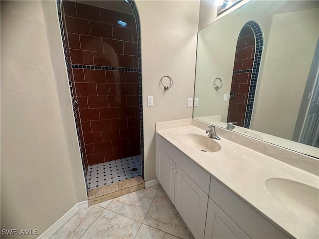 bathroom featuring a tile shower and vanity