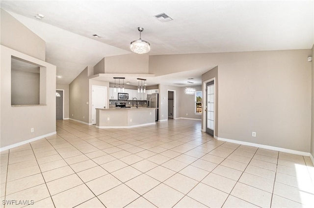 unfurnished living room featuring sink, light tile patterned floors, lofted ceiling, and an inviting chandelier