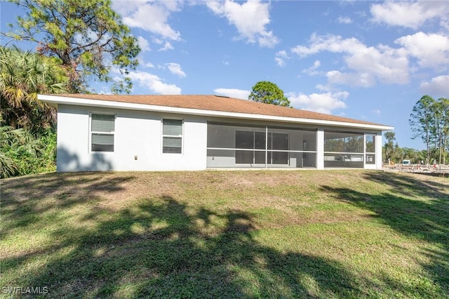 back of house featuring a yard and a sunroom