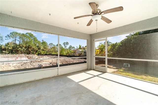 unfurnished sunroom featuring ceiling fan