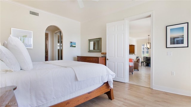 bedroom with ceiling fan, light hardwood / wood-style floors, and crown molding