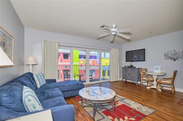 living room featuring ceiling fan and dark wood-type flooring