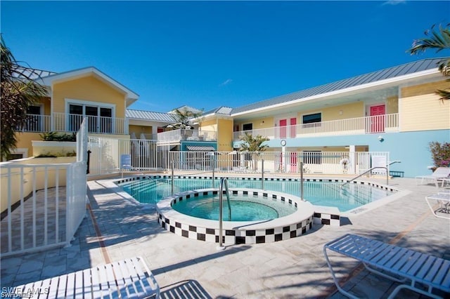 view of swimming pool featuring a patio area and a hot tub