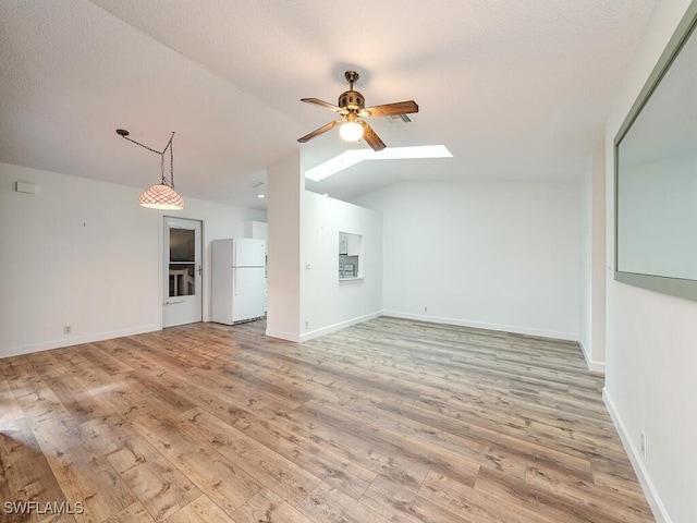 unfurnished living room featuring a textured ceiling, light wood-type flooring, ceiling fan, and vaulted ceiling with skylight