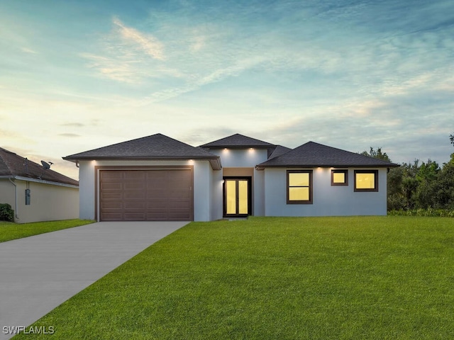 prairie-style home featuring a yard and a garage