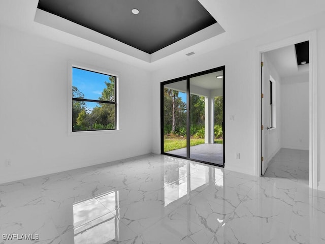 unfurnished room featuring recessed lighting, visible vents, a raised ceiling, and marble finish floor