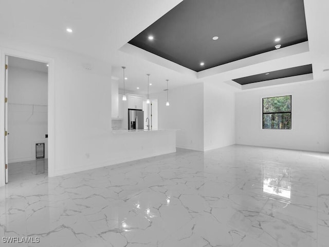 unfurnished room with recessed lighting, marble finish floor, a raised ceiling, and baseboards