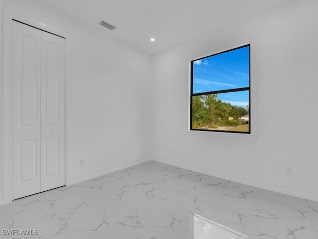 spare room featuring recessed lighting, baseboards, and marble finish floor