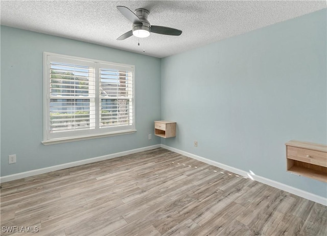 unfurnished room featuring a textured ceiling, light wood-type flooring, and ceiling fan