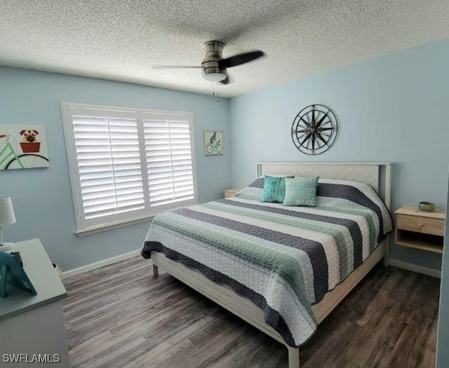 bedroom with dark hardwood / wood-style floors, ceiling fan, and a textured ceiling