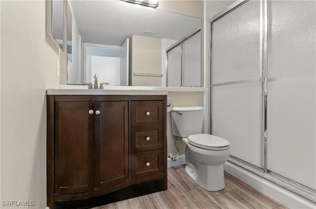 bathroom with vanity, toilet, wood-type flooring, and walk in shower