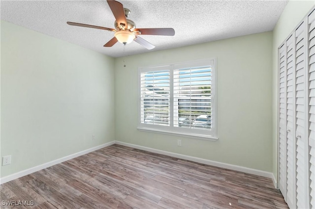 empty room featuring ceiling fan, light hardwood / wood-style floors, and a textured ceiling