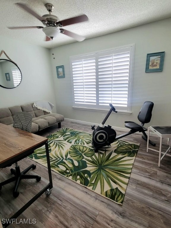 living room featuring ceiling fan, a textured ceiling, and hardwood / wood-style flooring