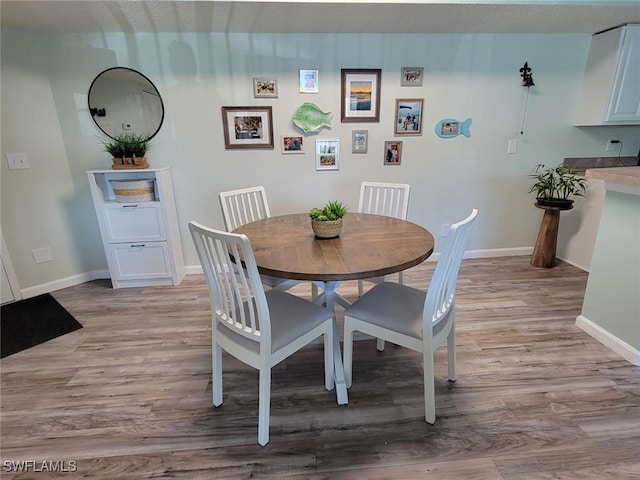 dining room with light hardwood / wood-style floors and a textured ceiling