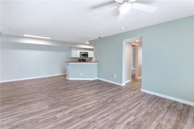 unfurnished living room featuring a textured ceiling, light hardwood / wood-style flooring, and ceiling fan